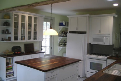 Kitchen - mid-sized transitional l-shaped kitchen idea in Cincinnati with an island, shaker cabinets, white cabinets, wood countertops, white appliances and an undermount sink