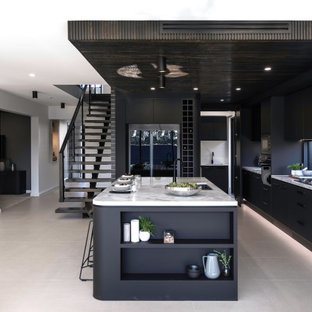 Inspiration for a contemporary l-shaped kitchen in Sydney with flat-panel cabinets, black cabinets, black appliances, with island, grey floor, white benchtop and wood.