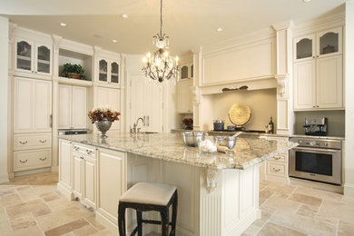 Inspiration for a large traditional l-shaped kitchen/diner in Miami with raised-panel cabinets, white cabinets, engineered stone countertops, stainless steel appliances, an island, a submerged sink, slate flooring and beige floors.