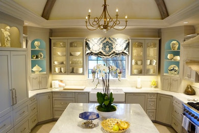 Example of a kitchen design in Dallas with a farmhouse sink, stainless steel appliances and an island