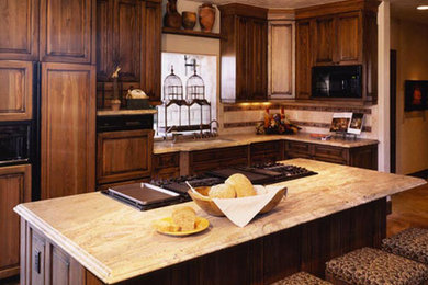 Mid-sized l-shaped eat-in kitchen photo in Denver with raised-panel cabinets, dark wood cabinets, granite countertops, beige backsplash, ceramic backsplash, black appliances and an island