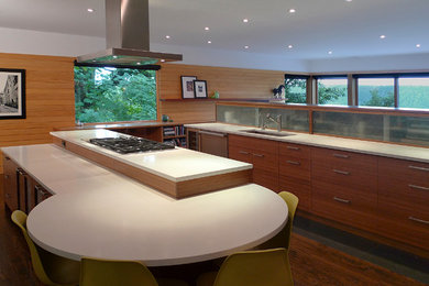 Inspiration for a large modern u-shaped open plan kitchen in New York with a submerged sink, flat-panel cabinets, medium wood cabinets, engineered stone countertops, beige splashback, wood splashback, stainless steel appliances, medium hardwood flooring, an island, brown floors and white worktops.