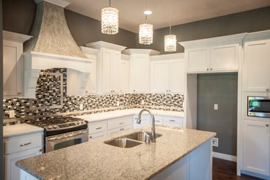 Example of a mid-sized transitional l-shaped dark wood floor and brown floor kitchen design in Other with an undermount sink, shaker cabinets, white cabinets, marble countertops, multicolored backsplash, mosaic tile backsplash, stainless steel appliances and an island