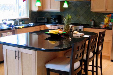 サンフランシスコにある高級な中くらいなトラディショナルスタイルのおしゃれなキッチン (レイズドパネル扉のキャビネット、石スラブのキッチンパネル、シルバーの調理設備、淡色無垢フローリング、ダブルシンク、淡色木目調キャビネット、人工大理石カウンター、黒いキッチンパネル、ベージュの床) の写真
