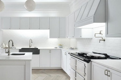 Inspiration for a mid-sized contemporary u-shaped kitchen pantry remodel in Houston with an undermount sink, flat-panel cabinets, white cabinets, solid surface countertops, stainless steel appliances and an island