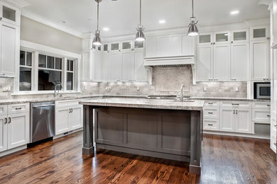 Example of a large trendy u-shaped dark wood floor and brown floor open concept kitchen design in Detroit with a drop-in sink, white cabinets, granite countertops, white backsplash, stainless steel appliances and an island
