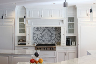 Example of a mid-sized transitional u-shaped eat-in kitchen design in Chicago with an undermount sink, raised-panel cabinets, white cabinets, marble countertops, white backsplash, mosaic tile backsplash, stainless steel appliances, an island and white countertops