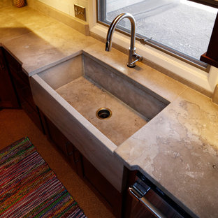 This is an example of a mid-sized industrial kitchen in Other with a farmhouse sink, shaker cabinets, dark wood cabinets, concrete benchtops, white splashback, subway tile splashback, stainless steel appliances, cork floors and brown floor.