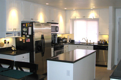 サンディエゴにある中くらいなトラディショナルスタイルのおしゃれなキッチン (ダブルシンク、レイズドパネル扉のキャビネット、白いキャビネット、人工大理石カウンター、シルバーの調理設備) の写真