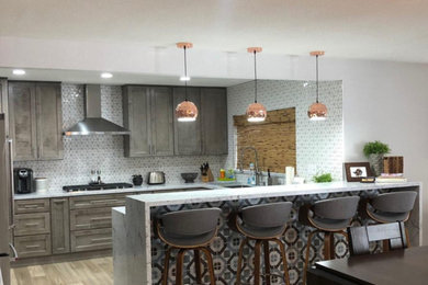 Eat-in kitchen - mid-sized l-shaped light wood floor eat-in kitchen idea in Other with a double-bowl sink, shaker cabinets, gray cabinets, granite countertops, white backsplash, mosaic tile backsplash, stainless steel appliances, an island and gray countertops