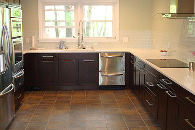 Kitchen - traditional kitchen idea in St Louis with dark wood cabinets and white backsplash