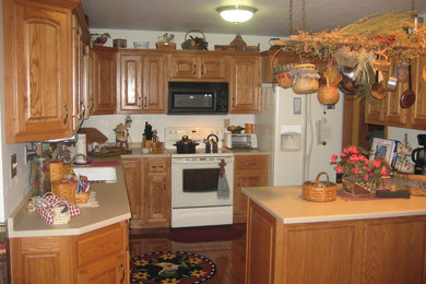Enclosed kitchen - mid-sized traditional u-shaped medium tone wood floor and brown floor enclosed kitchen idea in Other with a drop-in sink, raised-panel cabinets, medium tone wood cabinets, laminate countertops and white appliances