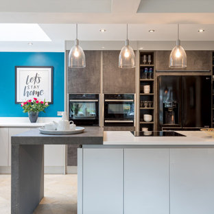 Photo of a medium sized contemporary u-shaped kitchen in Sussex with a submerged sink, flat-panel cabinets, white cabinets, an island, beige floors and white worktops.