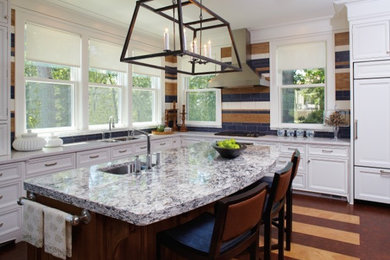 Mid-sized transitional l-shaped laminate floor eat-in kitchen photo in New York with recessed-panel cabinets, white cabinets, stainless steel appliances, an island, an undermount sink, granite countertops, multicolored backsplash and subway tile backsplash
