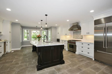 Inspiration for a huge u-shaped kitchen remodel in New York with white cabinets, marble countertops, stainless steel appliances and an island