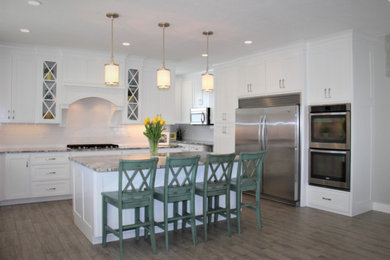 Large transitional u-shaped medium tone wood floor and gray floor enclosed kitchen photo in Salt Lake City with shaker cabinets, white cabinets, granite countertops, white backsplash, subway tile backsplash, stainless steel appliances, an island and gray countertops