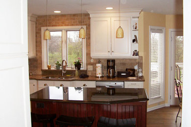 Example of a kitchen design in Chicago with flat-panel cabinets, white cabinets, granite countertops and an island