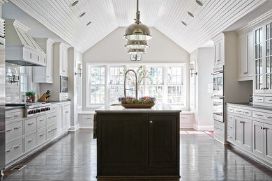 Esempio di una cucina classica con lavello sottopiano, ante lisce, top in marmo, paraspruzzi bianco, elettrodomestici in acciaio inossidabile e pavimento in legno massello medio