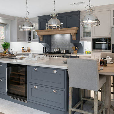 Mid-sized transitional l-shaped ceramic tile and beige floor kitchen photo in Hampshire with gray cabinets, solid surface countertops, stainless steel appliances, an island, shaker cabinets, gray backsplash and subway tile backsplash