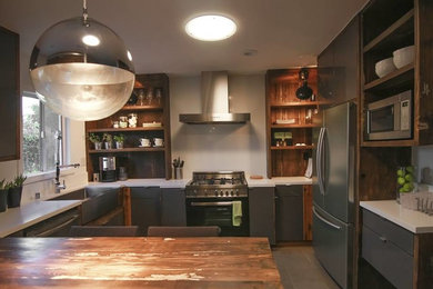 オースティンにある広いトラディショナルスタイルのおしゃれなキッチン (フラットパネル扉のキャビネット、グレーのキャビネット、シルバーの調理設備) の写真