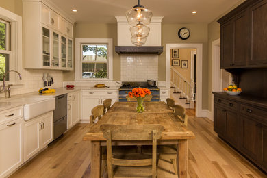 Eat-in kitchen - mid-sized traditional l-shaped medium tone wood floor eat-in kitchen idea in Boston with a farmhouse sink, recessed-panel cabinets, white cabinets, ceramic backsplash, colored appliances and no island