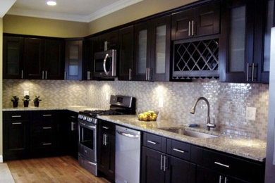 Kitchen - mid-sized traditional kitchen idea in DC Metro with a drop-in sink, recessed-panel cabinets, black cabinets, granite countertops and beige backsplash