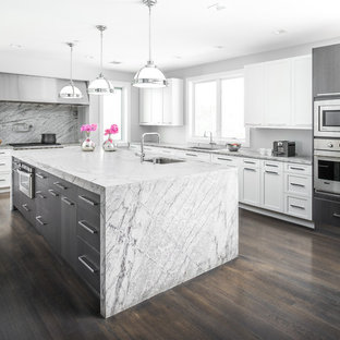 This is an example of a large contemporary l-shaped separate kitchen in New York with with island, a drop-in sink, flat-panel cabinets, white cabinets, marble benchtops, grey splashback, stainless steel appliances and plywood floors.