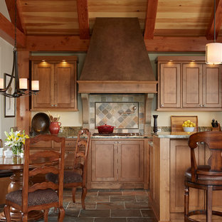 Photo of a large arts and crafts l-shaped eat-in kitchen in Minneapolis with beaded inset cabinets, stainless steel appliances, medium wood cabinets, an undermount sink, granite benchtops, multi-coloured splashback, slate floors, with island, slate splashback and multi-coloured floor.