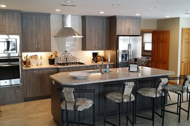 Example of a mid-sized transitional ceramic tile eat-in kitchen design in St Louis with an undermount sink, flat-panel cabinets, gray cabinets, quartzite countertops, white backsplash, ceramic backsplash, stainless steel appliances and an island