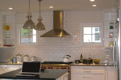 Large u-shaped kitchen photo in New York with white cabinets, white backsplash, subway tile backsplash and an island