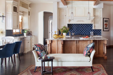 Inspiration for a mid-sized timeless l-shaped dark wood floor eat-in kitchen remodel in Denver with a farmhouse sink, raised-panel cabinets, beige cabinets, blue backsplash, granite countertops, ceramic backsplash, stainless steel appliances and an island