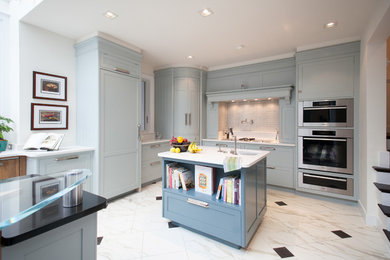 Inspiration for a large traditional open plan kitchen in Other with shaker cabinets, blue cabinets, grey splashback, metro tiled splashback, integrated appliances, engineered stone countertops, marble flooring, an island, white floors and white worktops.