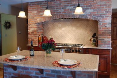 Exemple d'une cuisine chic en bois brun avec un placard avec porte à panneau surélevé, un plan de travail en quartz modifié, une crédence beige, une crédence en carreau de porcelaine et un électroménager en acier inoxydable.