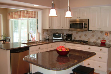 Imagen de cocina tradicional con encimera de granito, salpicadero blanco, salpicadero de azulejos de cerámica y electrodomésticos de acero inoxidable