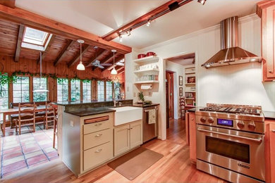 Inspiration for a large farmhouse u-shaped medium tone wood floor and brown floor kitchen remodel in San Luis Obispo with a farmhouse sink, shaker cabinets, light wood cabinets, stainless steel appliances and no island