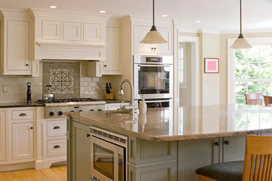 Example of a mid-sized transitional light wood floor and brown floor eat-in kitchen design in Other with shaker cabinets, white cabinets, granite countertops, beige backsplash, subway tile backsplash, stainless steel appliances and an island