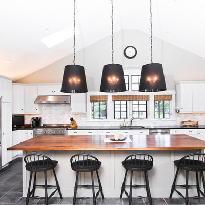 Example of a large transitional u-shaped slate floor and gray floor eat-in kitchen design in Boston with an undermount sink, white cabinets, wood countertops, gray backsplash, stone tile backsplash, stainless steel appliances, an island and shaker cabinets