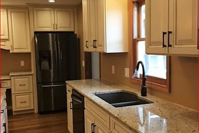 Eat-in kitchen - large medium tone wood floor and brown floor eat-in kitchen idea in Other with an undermount sink, raised-panel cabinets, white cabinets, granite countertops, stainless steel appliances and an island