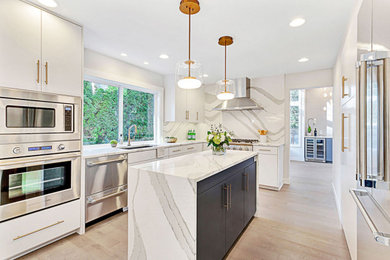 Example of a large minimalist l-shaped light wood floor and gray floor open concept kitchen design in Seattle with an undermount sink, flat-panel cabinets, white cabinets, quartz countertops, multicolored backsplash, quartz backsplash, stainless steel appliances, an island and multicolored countertops