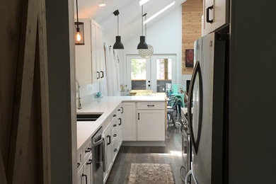 This is an example of a medium sized contemporary galley kitchen/diner in Other with a submerged sink, shaker cabinets, white cabinets, engineered stone countertops, stainless steel appliances, dark hardwood flooring and a breakfast bar.