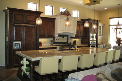Example of a mid-sized classic single-wall slate floor open concept kitchen design in Phoenix with a double-bowl sink, raised-panel cabinets, dark wood cabinets, quartzite countertops, subway tile backsplash, paneled appliances and an island