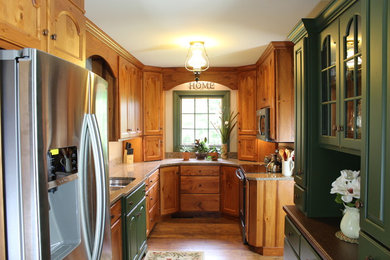 Example of a mid-sized classic galley medium tone wood floor enclosed kitchen design in Philadelphia with recessed-panel cabinets, medium tone wood cabinets, granite countertops, no island, a double-bowl sink and stainless steel appliances