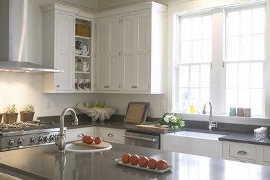 Klassische Küche mit Landhausspüle, Schrankfronten im Shaker-Stil, weißen Schränken, Küchenrückwand in Weiß, Küchengeräten aus Edelstahl und Kücheninsel in Charlotte