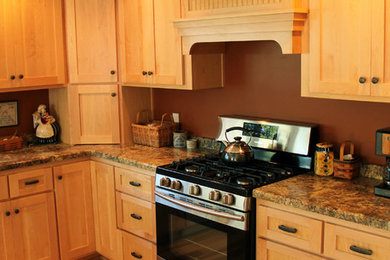 Example of a large classic u-shaped light wood floor eat-in kitchen design in Milwaukee with a drop-in sink, recessed-panel cabinets, light wood cabinets, stainless steel appliances and no island