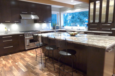 Inspiration for a large modern u-shaped medium tone wood floor eat-in kitchen remodel in Vancouver with an undermount sink, flat-panel cabinets, dark wood cabinets, granite countertops, gray backsplash, glass tile backsplash, stainless steel appliances and an island