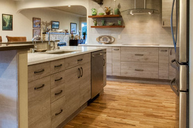 Design ideas for a small retro l-shaped open plan kitchen in Seattle with a double-bowl sink, flat-panel cabinets, beige cabinets, engineered stone countertops, beige splashback, ceramic splashback, stainless steel appliances, light hardwood flooring and an island.