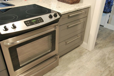Foto de cocina minimalista de tamaño medio con fregadero sobremueble, armarios estilo shaker, puertas de armario grises y electrodomésticos de acero inoxidable