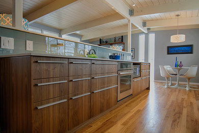 Example of a 1950s galley eat-in kitchen design in Denver with an undermount sink, flat-panel cabinets, dark wood cabinets, quartz countertops, blue backsplash, glass tile backsplash and stainless steel appliances