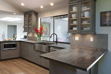 Inspiration for a large contemporary u-shaped medium tone wood floor and brown floor eat-in kitchen remodel in Seattle with a farmhouse sink, flat-panel cabinets, gray cabinets, gray backsplash and stainless steel appliances