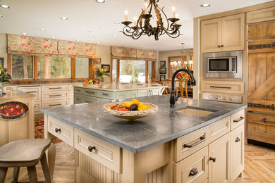 Example of a large classic porcelain tile kitchen design in Denver with an undermount sink, recessed-panel cabinets, beige cabinets, quartz countertops, multicolored backsplash, stone tile backsplash, paneled appliances and two islands